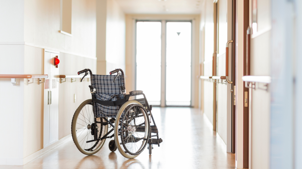 Empty wheelchair in a hospital hallway representing a senior's transition from hospital to home care.