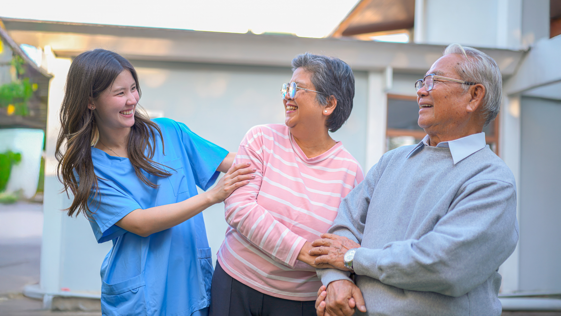 Caregiver sharing a joyful moment with seniors receiving companionship care in Lansing, Michigan.