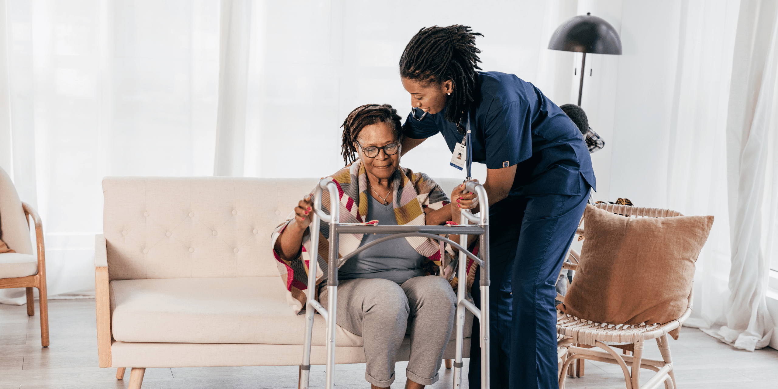 Professional caregiver helping an older adult safely use a walker in the comfort of their home in Lansing, Michigan.